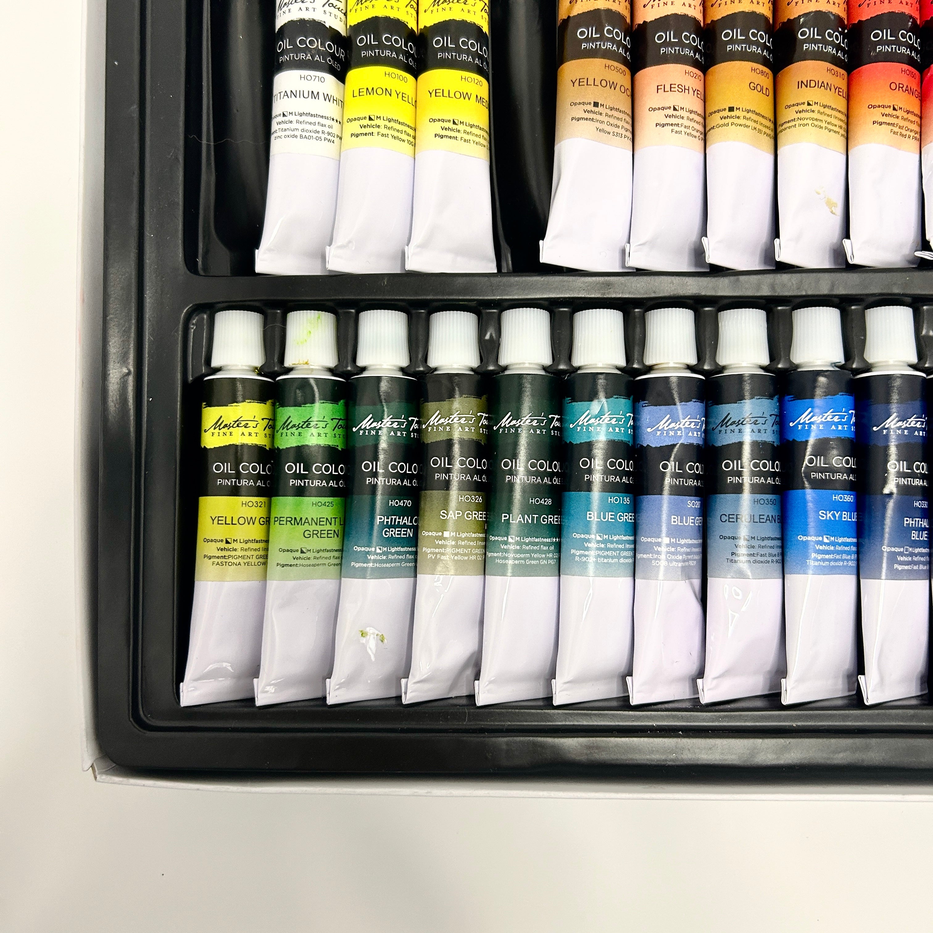Set of oil paint tubes in a black tray on a white background