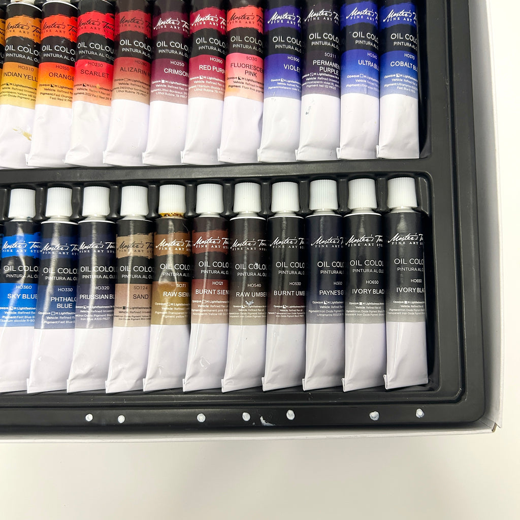 Set of oil paint tubes in a case on a white background
