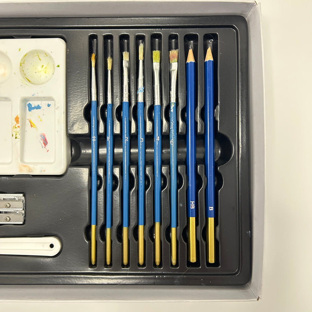 Set of art supplies including brushes, pencils, and a small palette in a black holder.