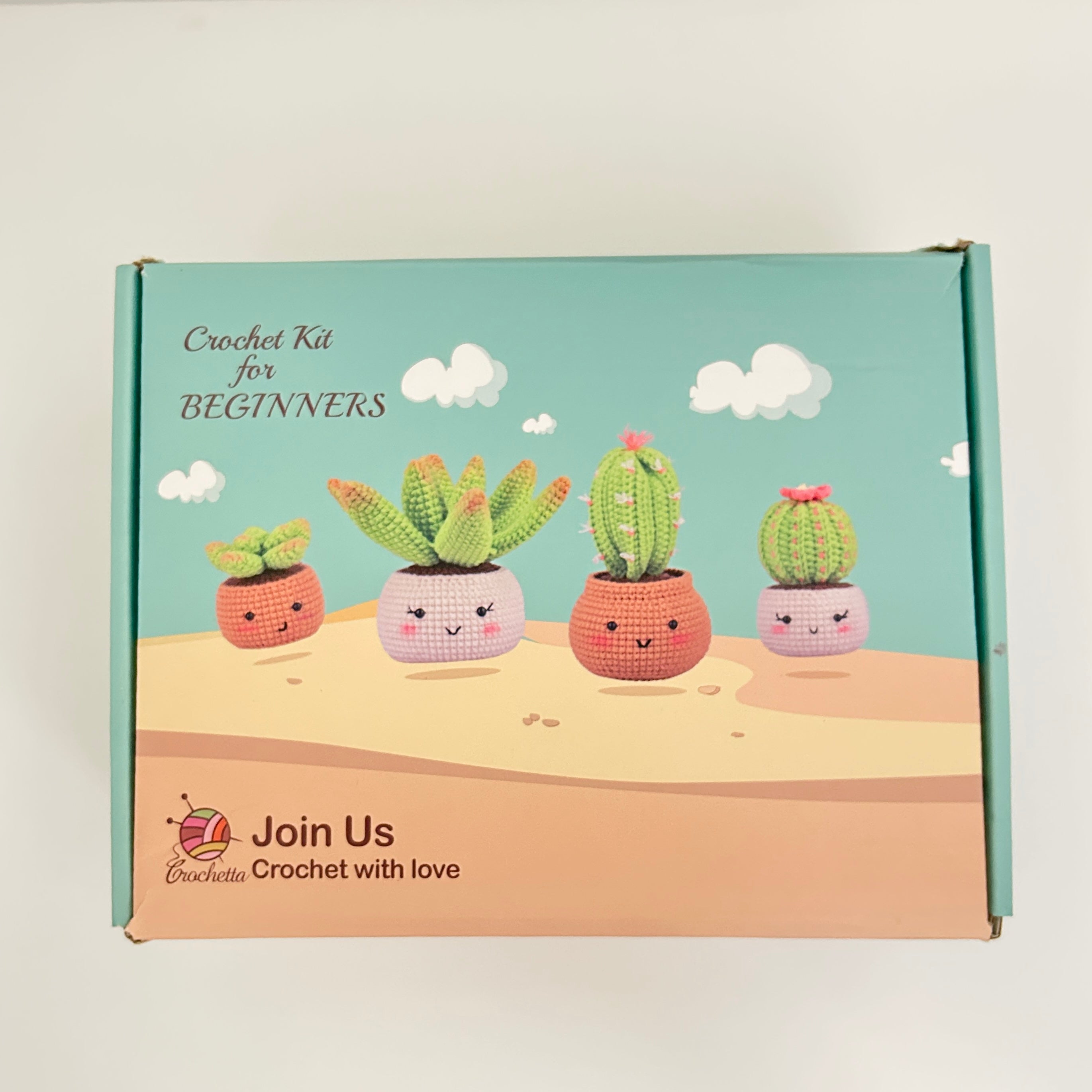 Crochet kit for beginners packaging with cartoon cacti on a desert background